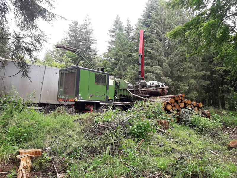 Wood chipper and cleared brush on a land clearing site
